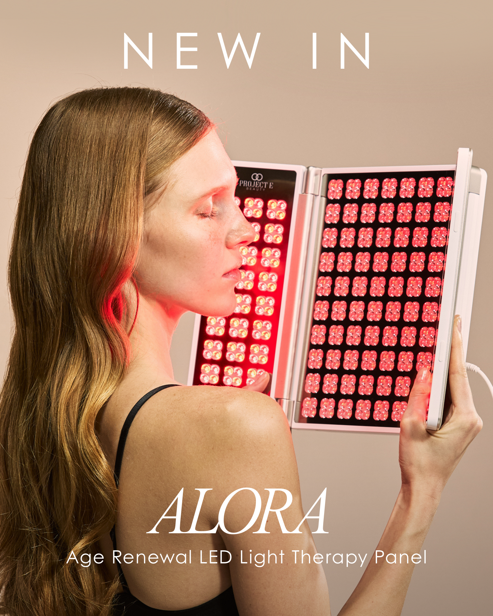 A woman showcasing Alora Age Renewal LED light therapy panel for cell regeneration and skin rejuvenation.