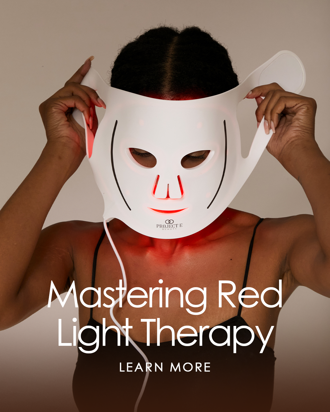 Model putting on an LED mask in an ad for Project E Beauty's red light therapy