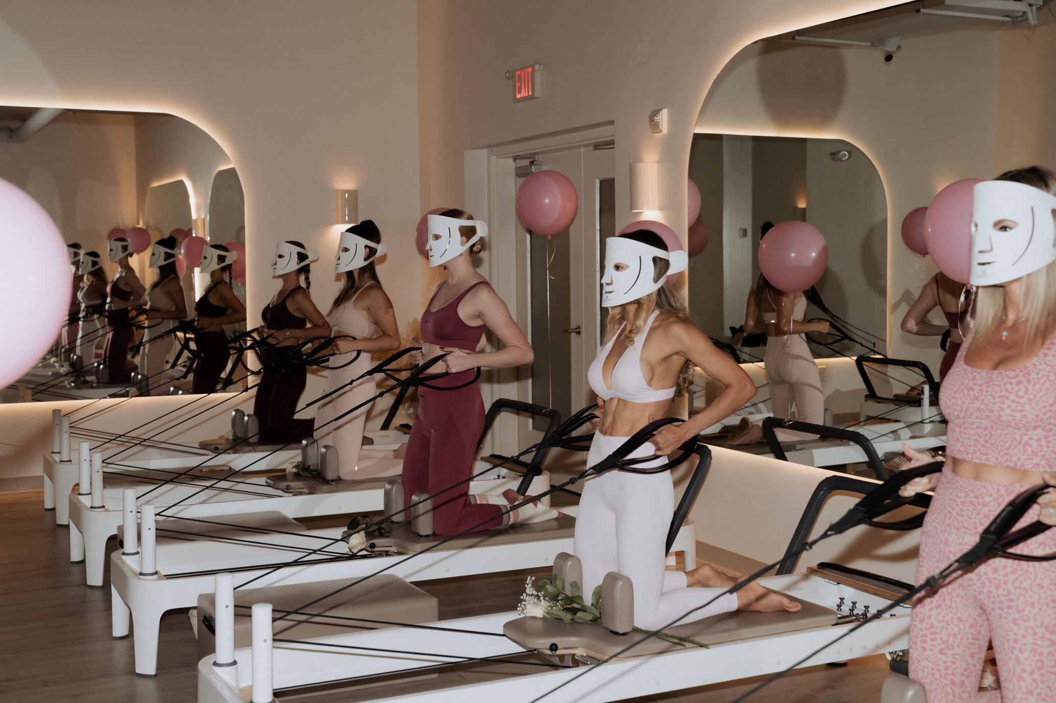 women combining Pilates routine with red light facial therapy
